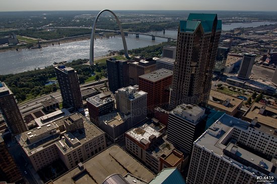 Aerial photo of a low flyover of downtown St. Louis with the Gateway Arch along the river to the east