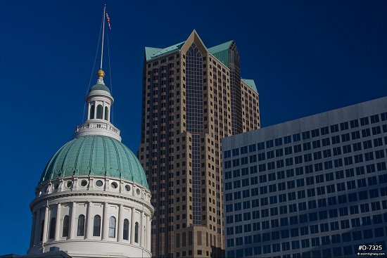 The Old Courthouse with downtown buildings in full sun under deep blue sky