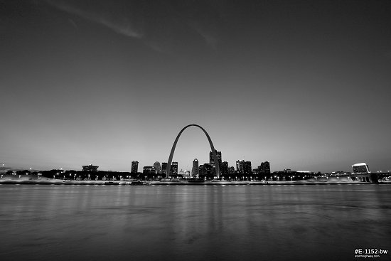 Subtle evening sunset rays over the Gateway Arch, Mississippi riverfront and downtown St. Louis, MO, black and white