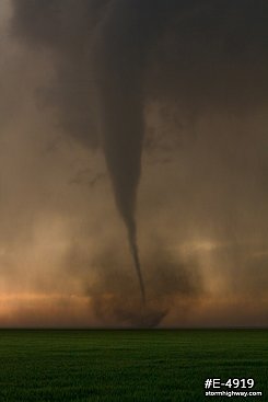 Drill-bit tornado with debris over the prairie at sunset near Rozel, Kansas