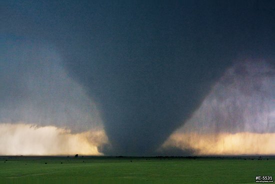 A large, strong EF4 tornado looms over green Kansas prairie near the town of Bennington